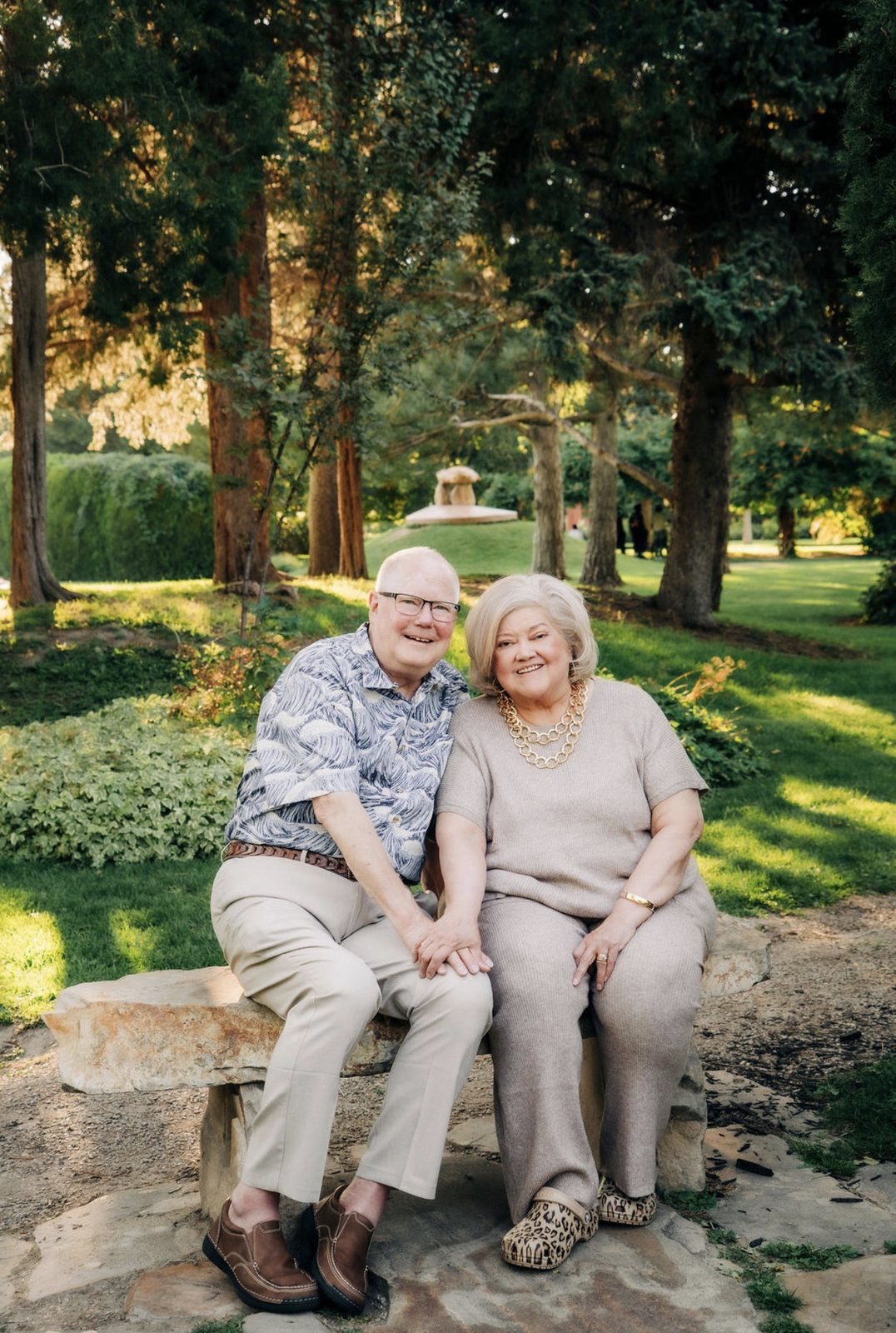 The family behind Isabella&rsquo;s Catering, sitting together on a stone bench in a tree-lined garden